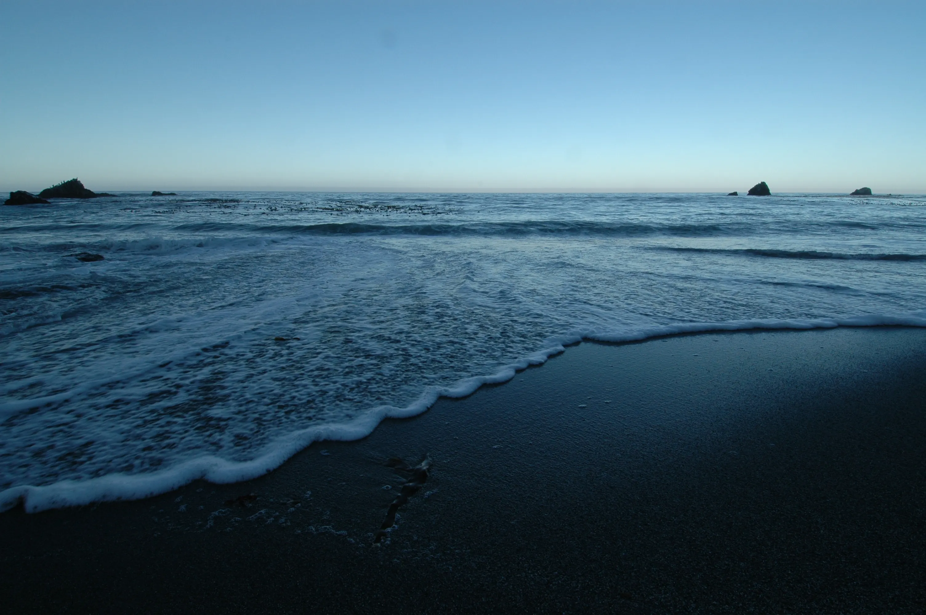 Wave lapping a beach at dusk